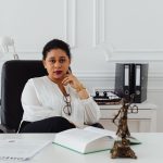 Portrait of a professional lawyer sitting confidently in a modern office, conveying authority.