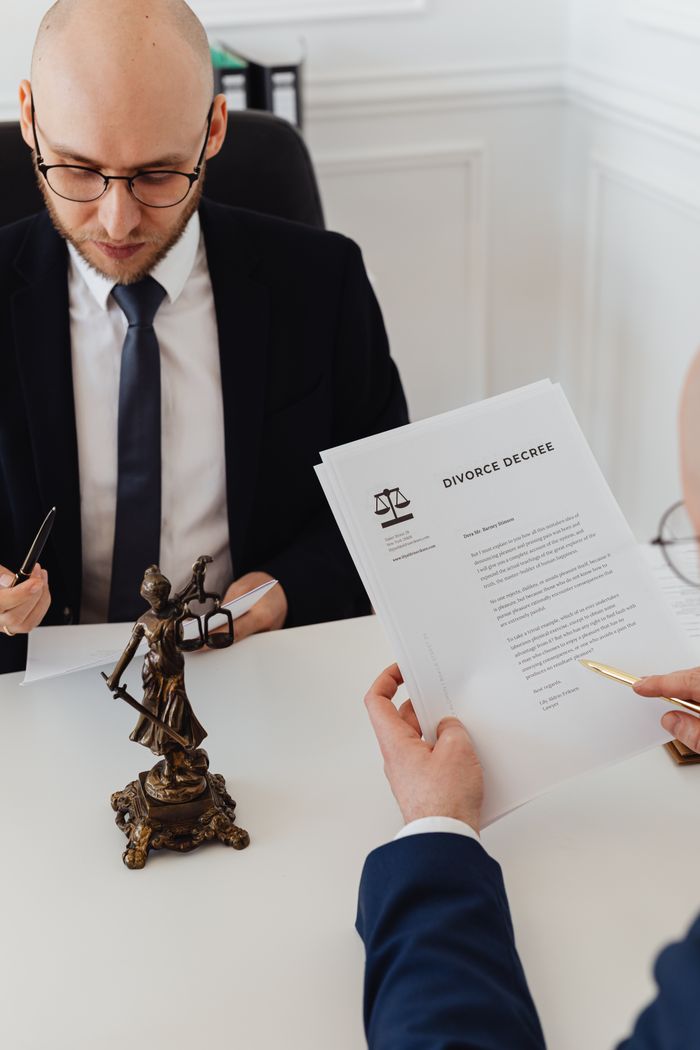 Two lawyers discussing divorce decree documents in a professional office setting.
