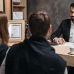 A lawyer in an elegant office meeting with clients, discussing documents.